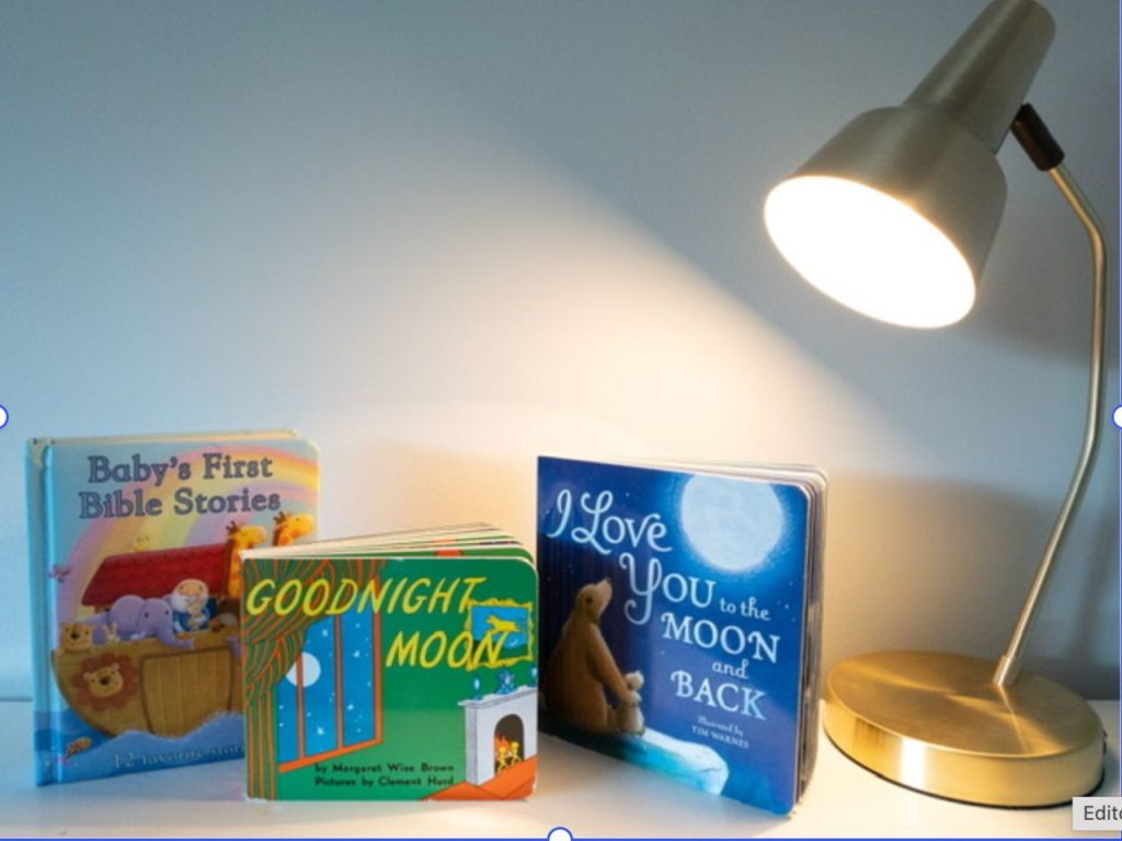 Baby's First Bible Stories, Goodnight Moon and I love you to the moon and back on a shelf with a lamp turned on.