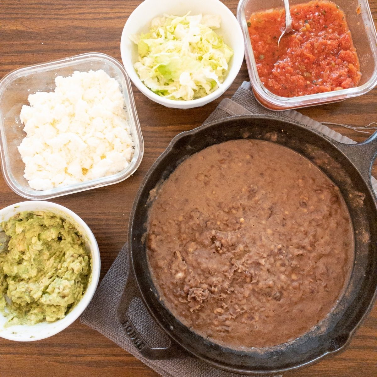 how to eat a tostada with homemade refried beans, creamy guac, queso fresco, and salsa