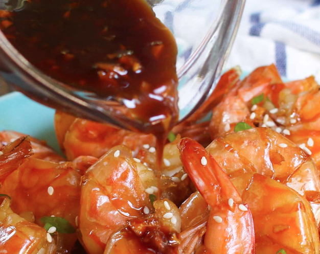 honey garlic sauce being poured over instant pot shrimp
