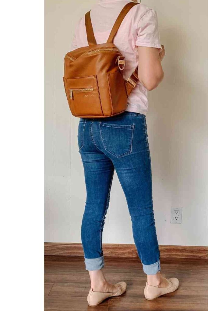 woman showing her faux leather backpack style purse.