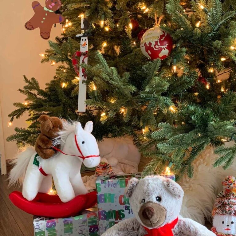 stuffed animals at the base of a decorated christmas tree