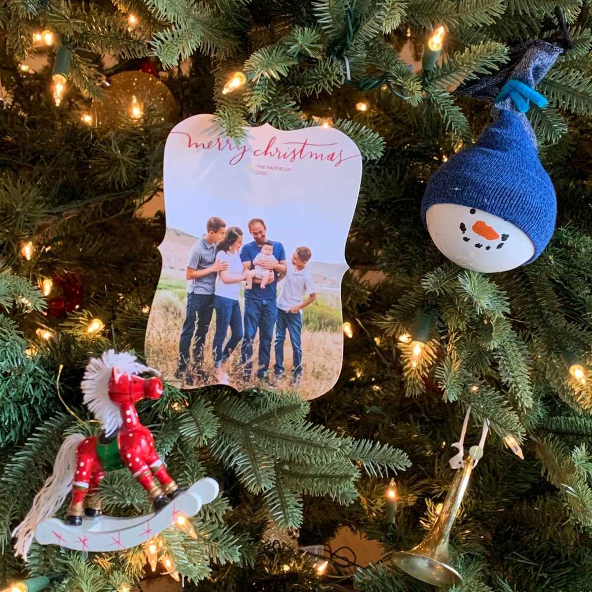 christmas cards used as ornaments on a christmas tree