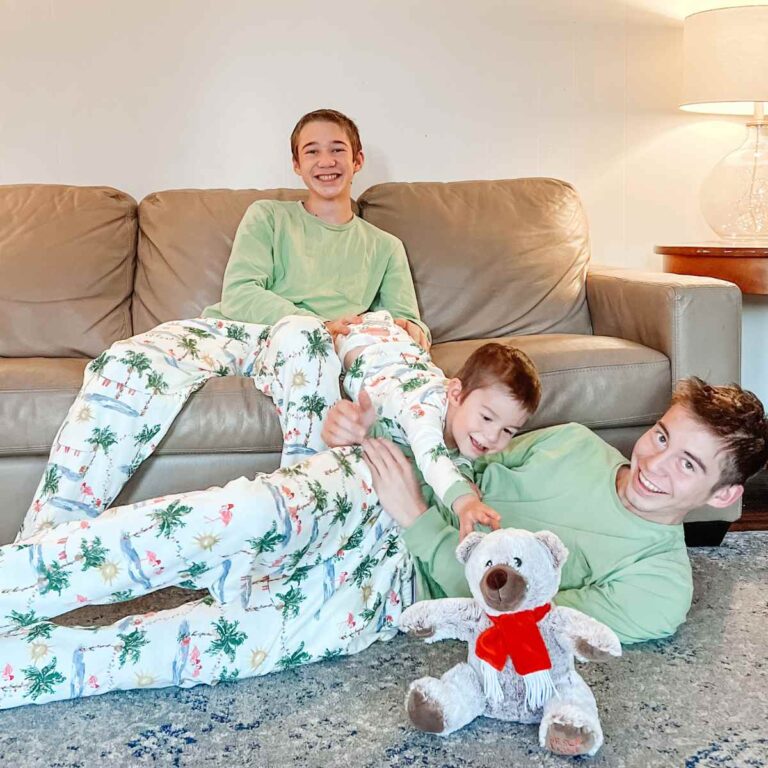 teenage boys paying around with baby brother at Christmas time