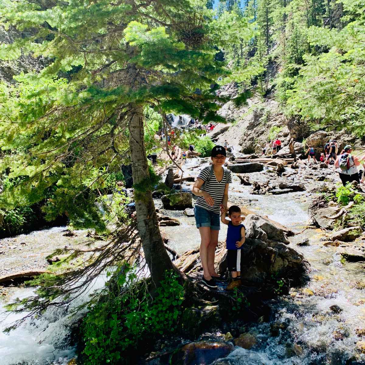 mom and toddler hiking up a river