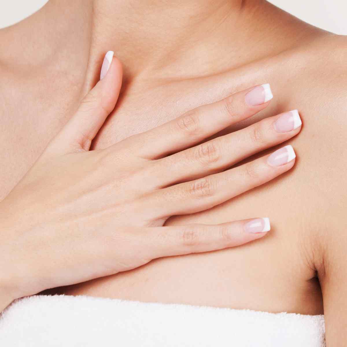 woman's hand on her décolletage area.