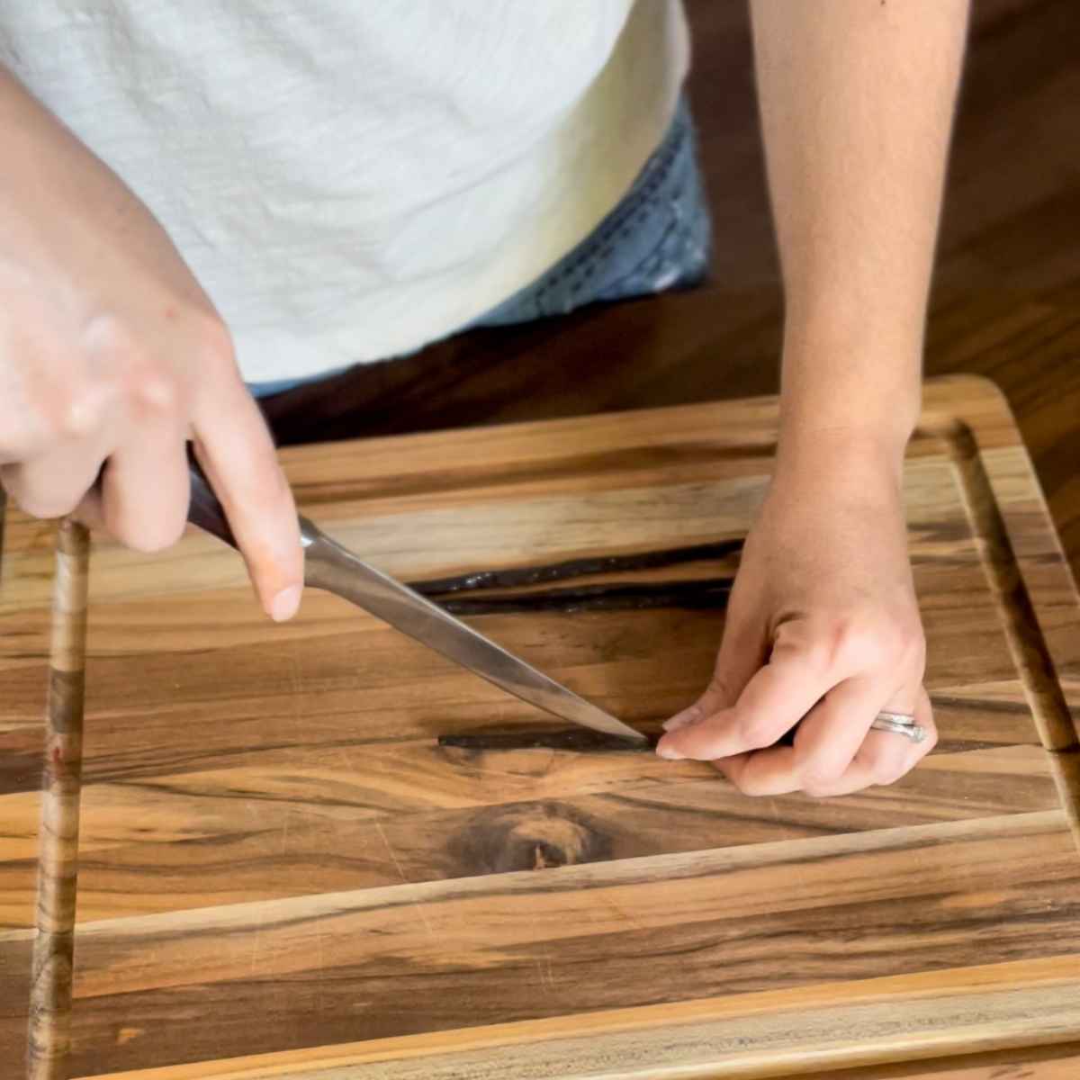 woman using a sharp knife to cut vanilla beans length wise