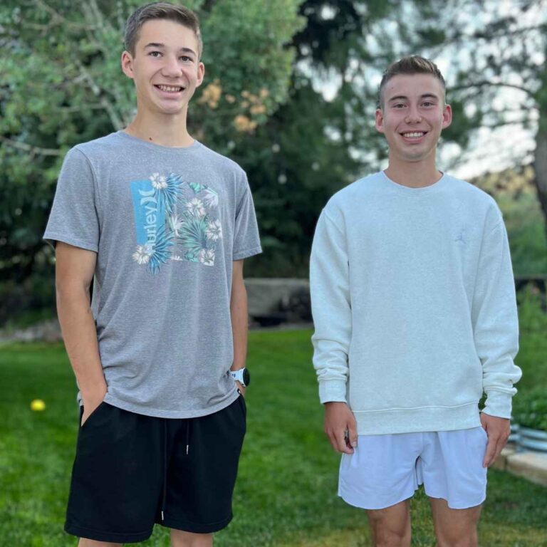 two teenage boys standing outside