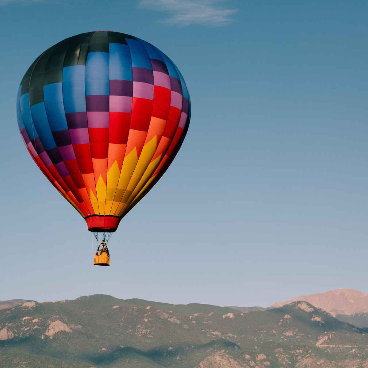hot air balloon flating above the hills