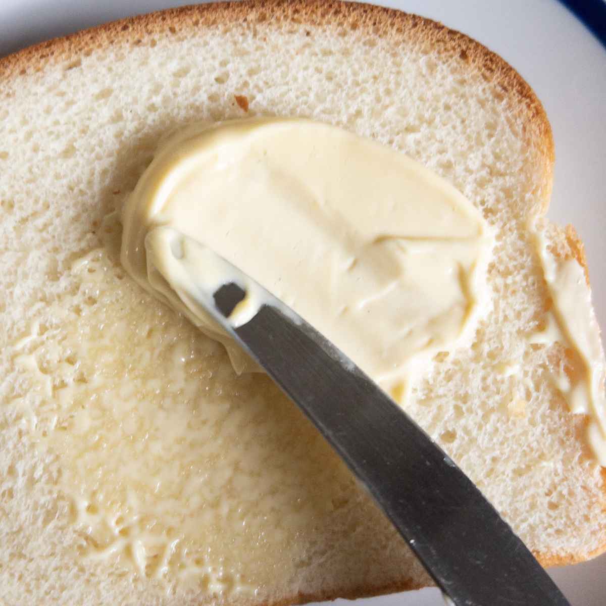spreading kombucha mayo on a piece of bread