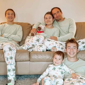 family of five in christmas pjs sitting in their living room
