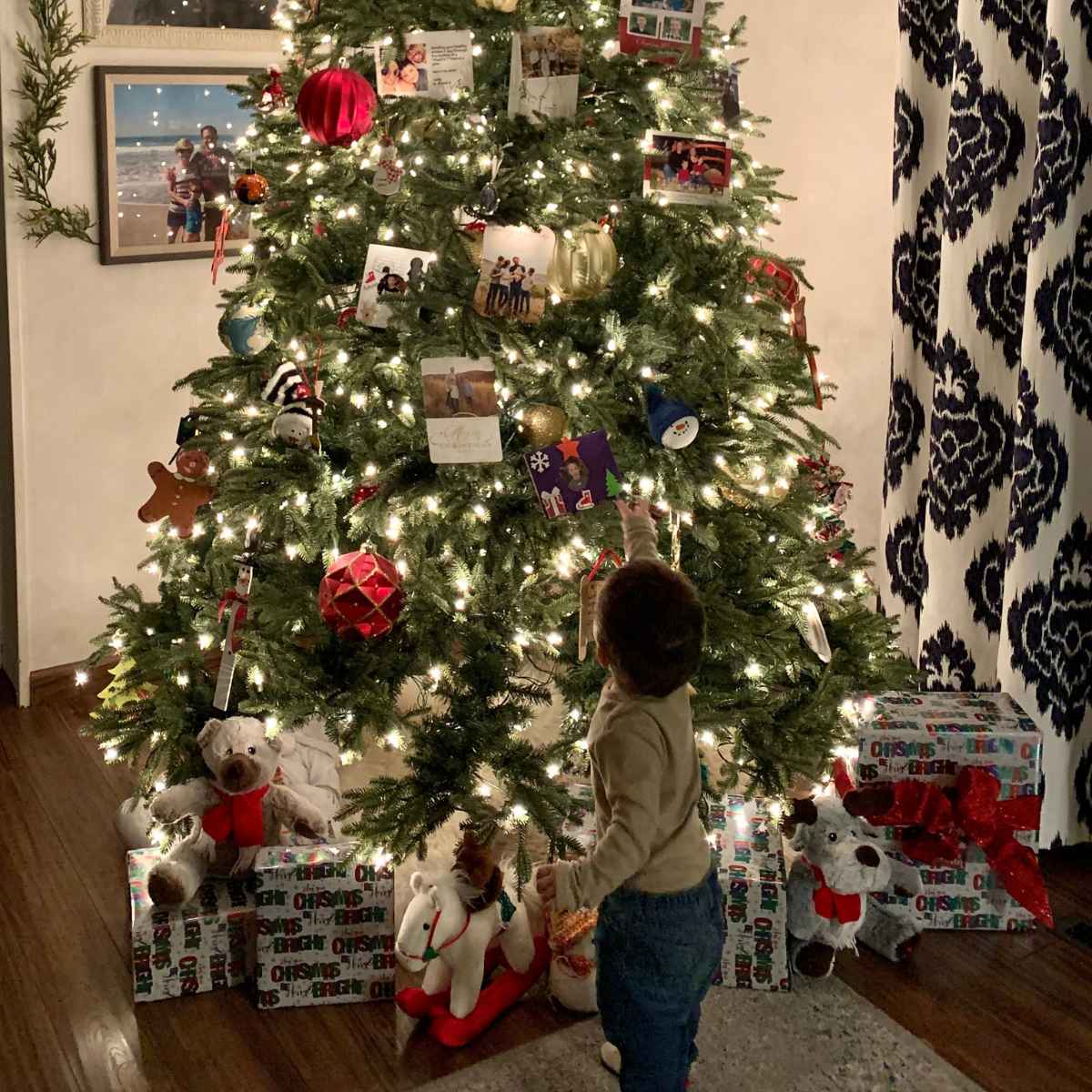 toddler looking up at the Christmas tree